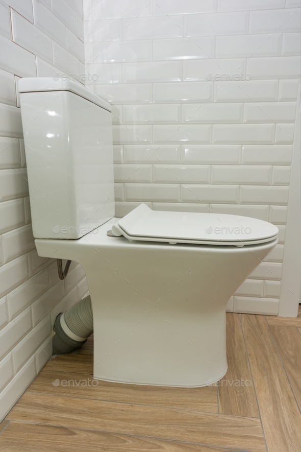 White ceramic toilet bowl in the bathroom interior closeup Stock Photo